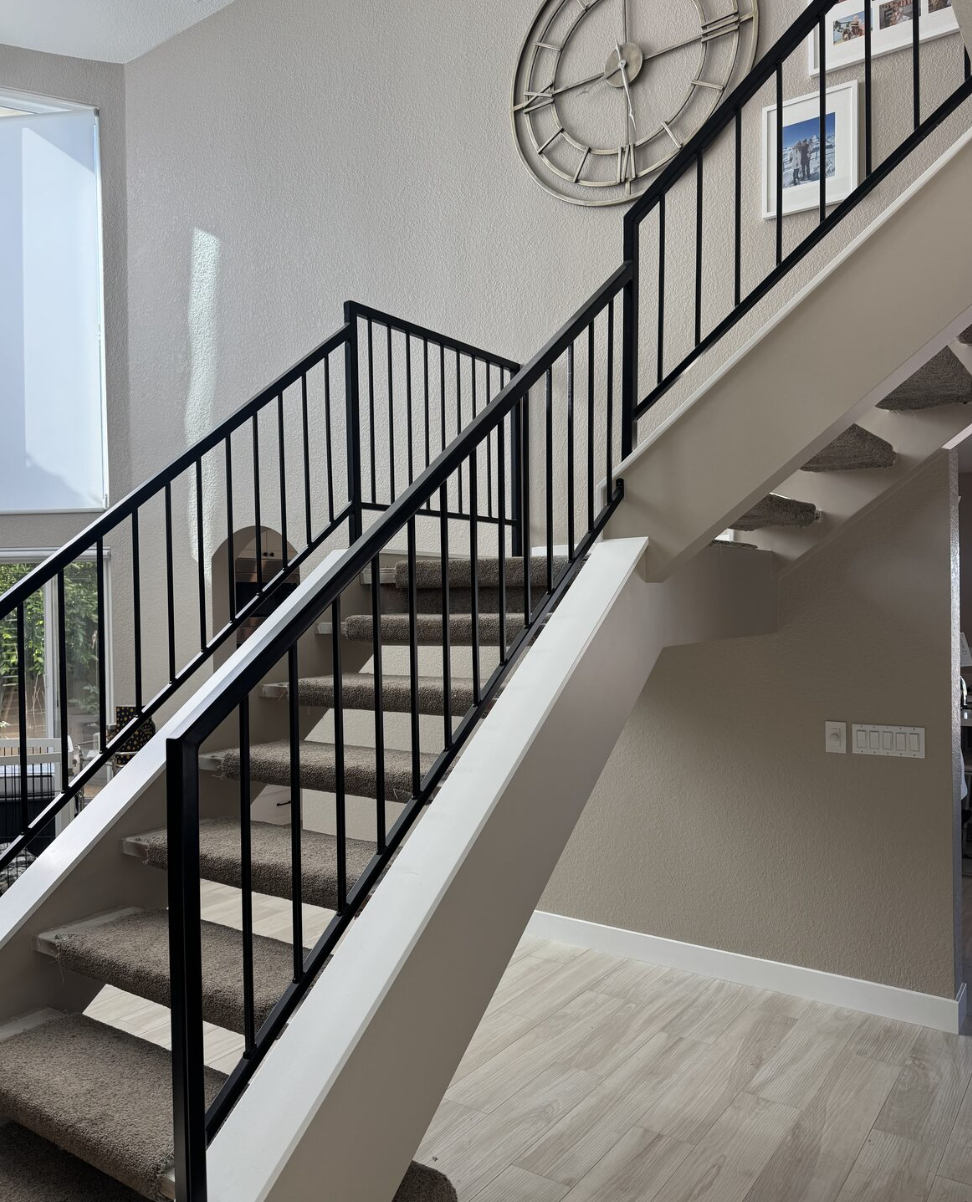 Custom staircase with black metal railing showcasing fine detail work